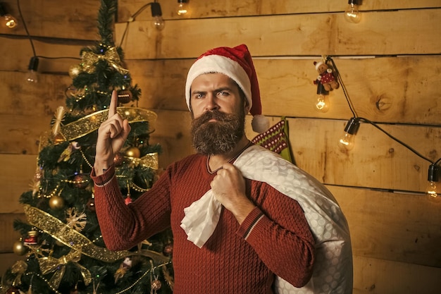 Chico de año nuevo en el árbol de Navidad con guirnalda.