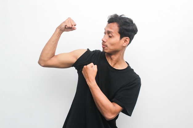 Chico asiático con camiseta negra mostrando sus músculos bíceps Concepto de modelo publicitario