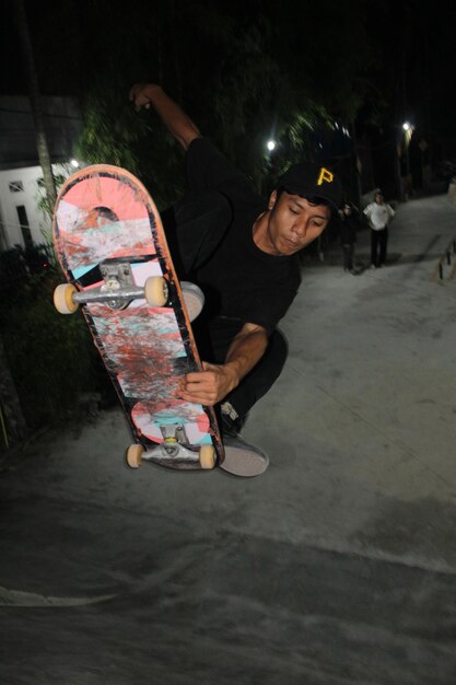 Chico asiático muestra sus habilidades de skate en el obstáculo del quarter pipe