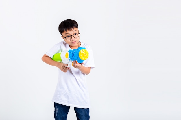 Foto chico asiático con pistola de agua en el fondo blanco