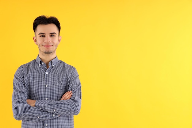 Chico atractivo en camisa sobre fondo amarillo