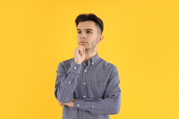 Chico atractivo en camisa sobre fondo amarillo