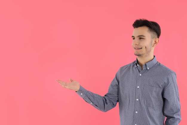 Chico atractivo en camisa sobre fondo rosa