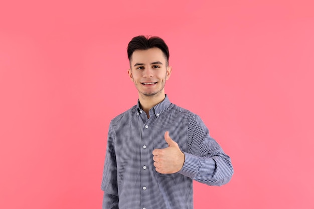 Chico atractivo en camisa sobre fondo rosa