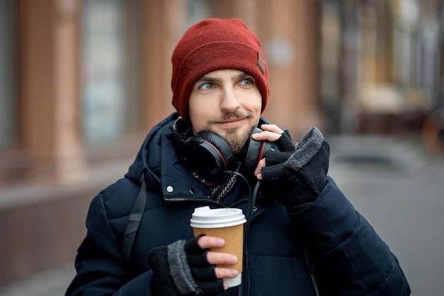 Chico con auriculares y café.