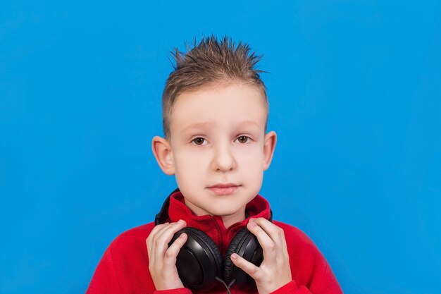 Chico con auriculares sobre una superficie azul