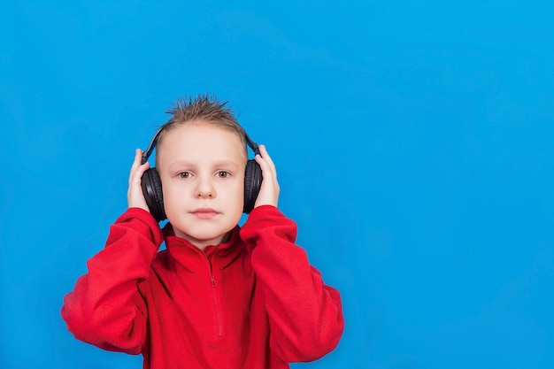 Chico con auriculares sobre una superficie azul