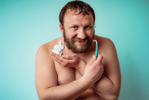 Chico barbudo feliz está listo para afeitarse la barba. Hombre afeitado.