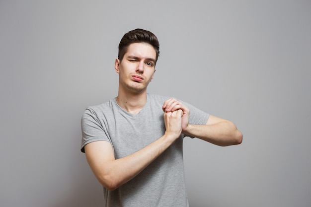 Un chico con una camiseta gris con emociones en su rostro.