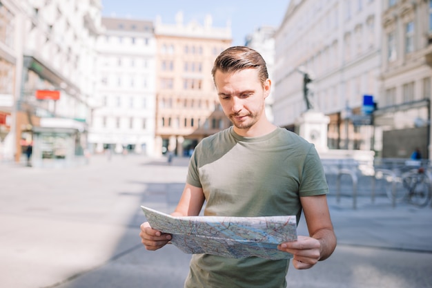 Chico caucásico mirando el mapa de la ciudad europea.