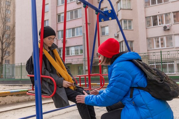 Chico y chica adolescentes en un paseo por la ciudad en primavera con ropa brillante