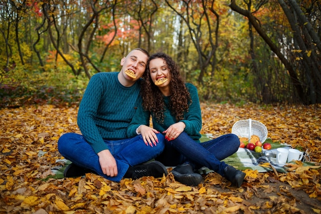 Un chico y una chica en el bosque de otoño con galletas.