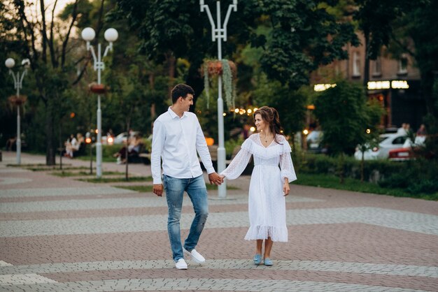 Un chico y una chica caminan felizmente por la mañana por las calles vacías de la vieja Europa