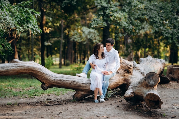 Chico y chica caminan por los senderos de un parque forestal entre árboles altos