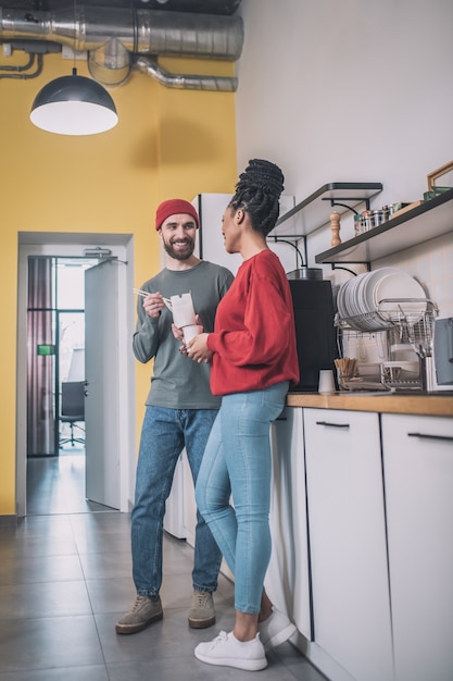 Chico y chica comunicándose en la cocina de la oficina