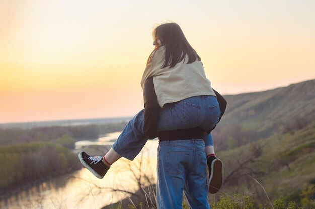 un chico y una chica enamorados divirtiéndose en la naturaleza al atardecer