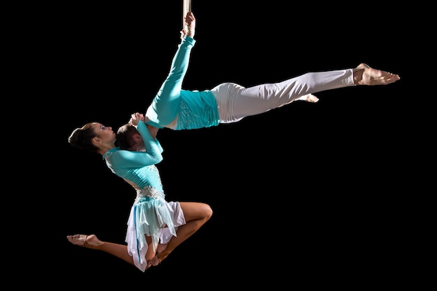 Chico y chica gimnastas colgando de una cuerda El show de acróbatas