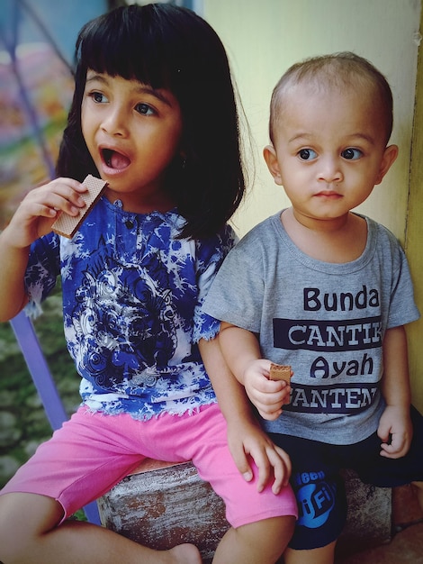 Foto un chico y una chica lindos comiendo chocolate en el interior.