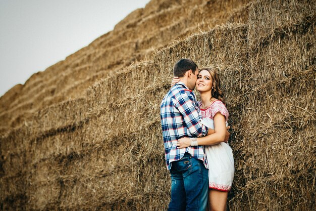 Foto un chico con una chica en un paseo de verano en el campo cerca de pajares redondos