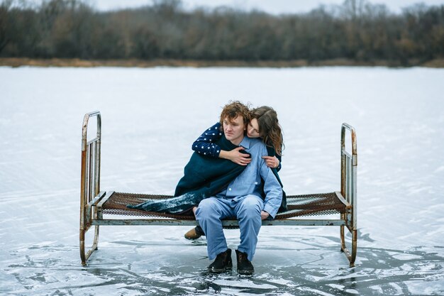 Un chico y una chica en pijama están en el hielo de un lago congelado.