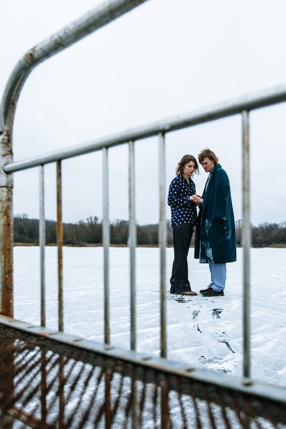 Un chico y una chica en pijama están en el hielo de un lago congelado.