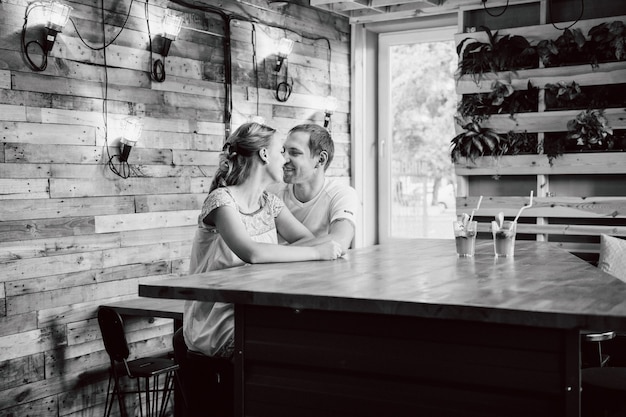 Chico y chica reunidos en un café estilizado de la ciudad