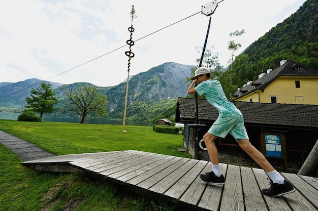 Chico columpiándose en la cuerda en el patio de recreo Hallstatt Austria