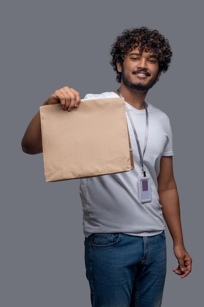 Chico complacido con el paquete en una mano mirando hacia adelante