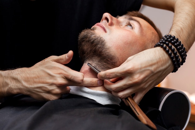 Chico cortándose la barba en una barbería