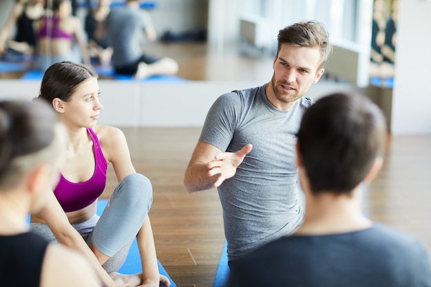 Chico deportivo compartiendo ideas en clase de yoga