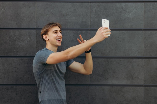 Chico deportivo haciendo foto selfie en pared negra