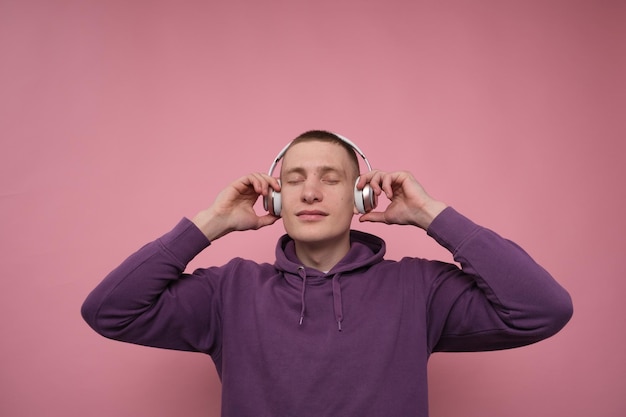 chico disfrutando y escuchando música en auriculares con los ojos cerrados