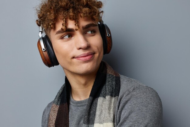 Chico elegante estilo elegante bufanda a cuadros auriculares fondo claro