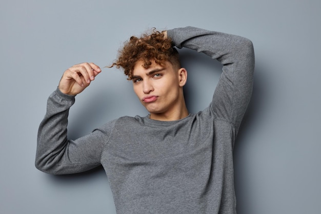 Chico elegante en un estudio de moda de sudadera gris fondo aislado