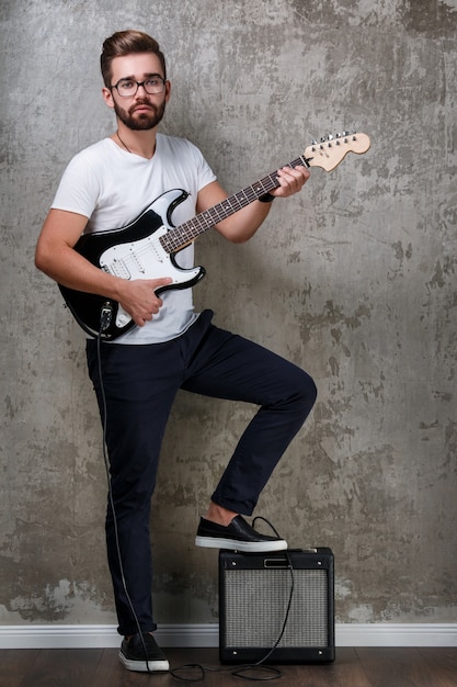 Chico elegante con una guitarra