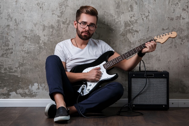 Chico elegante con una guitarra