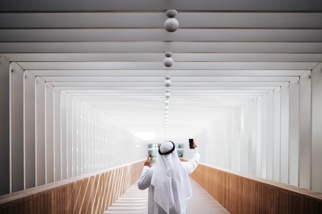 Chico emiratí tomando selfie en el estilo de vida urbano del centro de la ciudad el corazón de Dubai