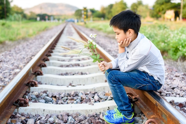 Chico esperando en el ferrocarril