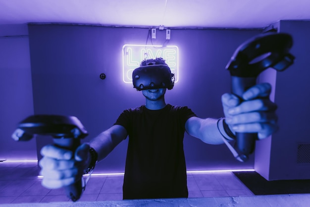 El chico está jugando juegos de realidad virtual. Luz azul neón. Foto de alta calidad