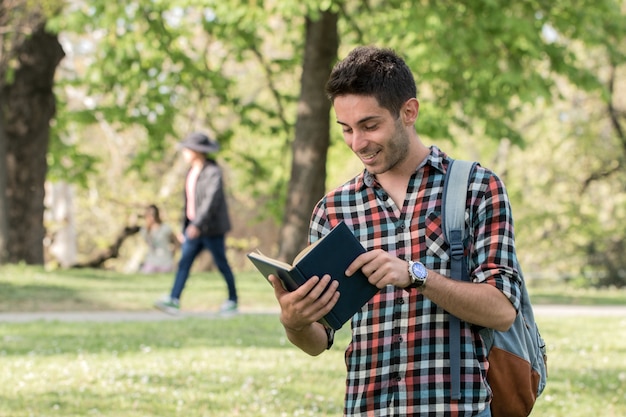 Chico estudiante haciendo los deberes en el parque.