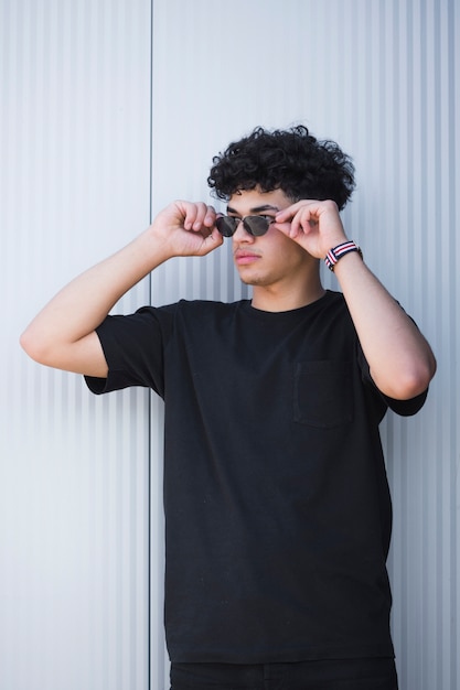 Foto chico étnico con estilo en gafas de sol con pelo rizado