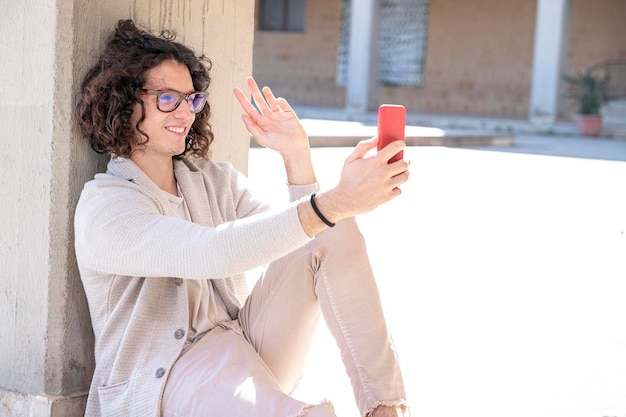 Chico europeo alegre haciendo una cita con su novia por teléfono