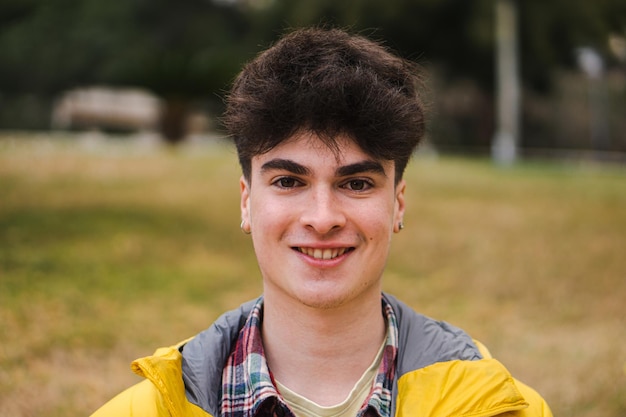 Chico feliz caucásico parado en el campus universitario Retrato de un estudiante adolescente mirando a la cámara