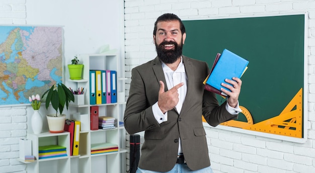 Chico feliz con libro de trabajo y libros listos para la escuela de lecciones