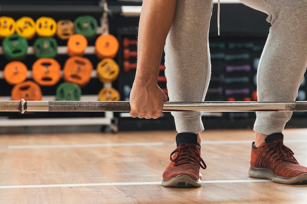 Chico fitness levantando pesas en el gimnasio