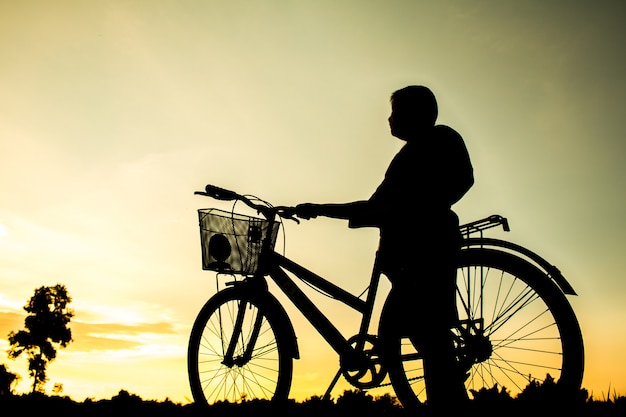 Un chico fitness silueta amanecer ciclismo entrenamiento concepto de bienestar