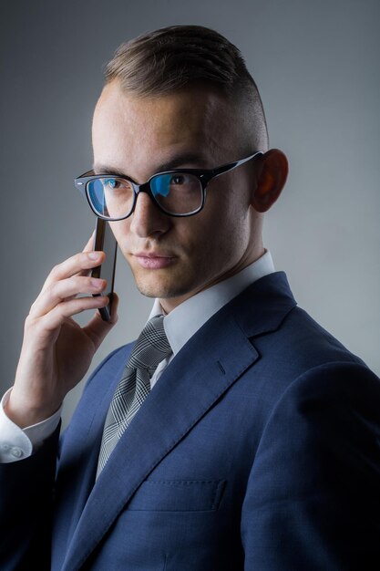 Foto chico con gafas con teléfono móvil