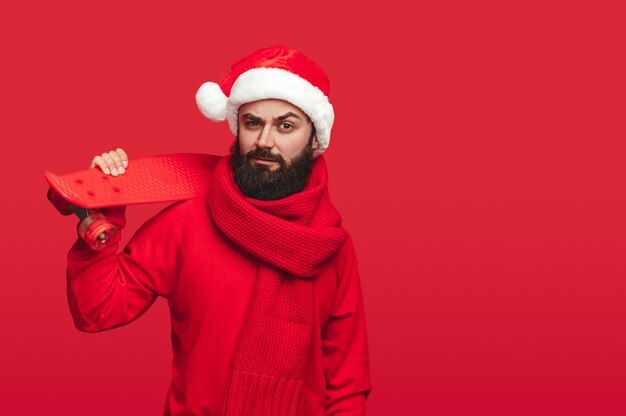 chico con gorro de Papá Noel con patineta