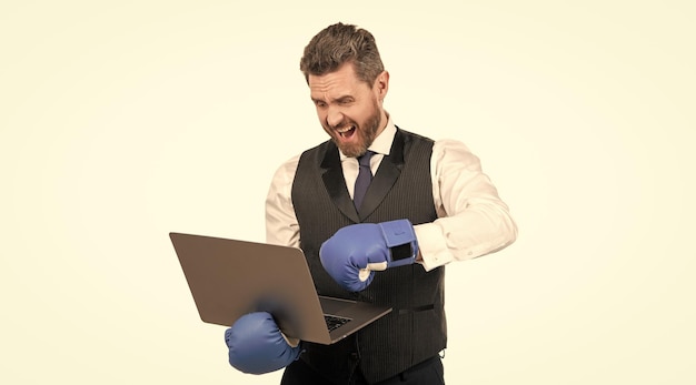 Chico gritando en guantes de boxeo y computadora de golpe de ropa formal aislado en blanco acoso cibernético