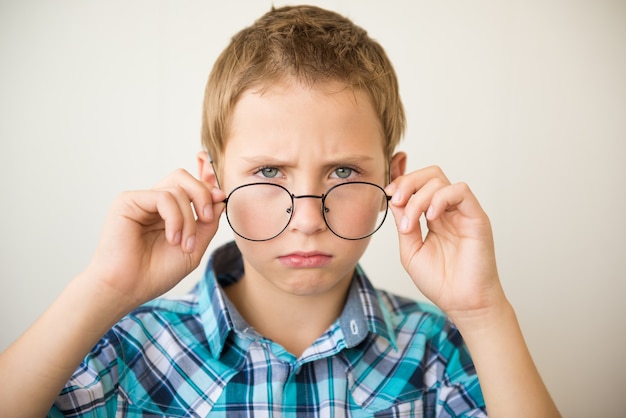 Chico guapo adolescente lleva gafas. Concepto de medicina y visión deficiente